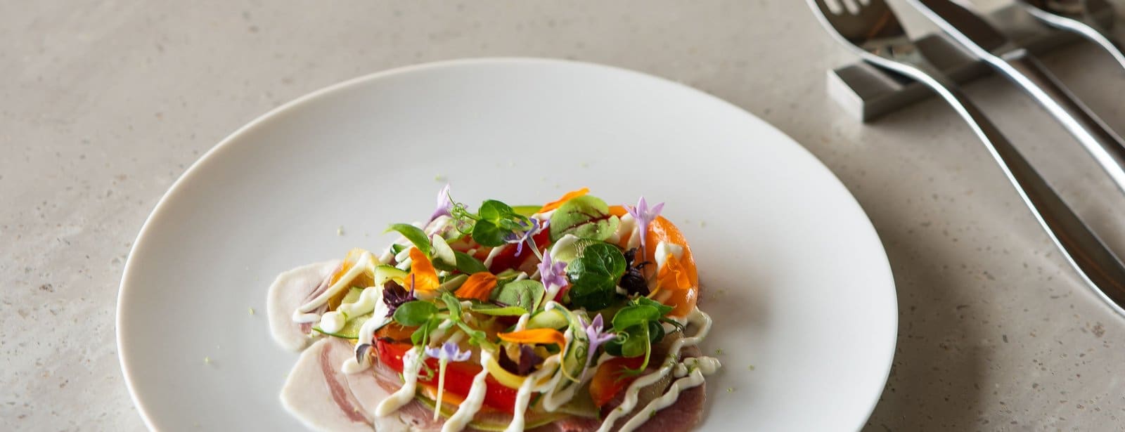 Plated dish with edible flowers from the Albert Park Head Chef placement